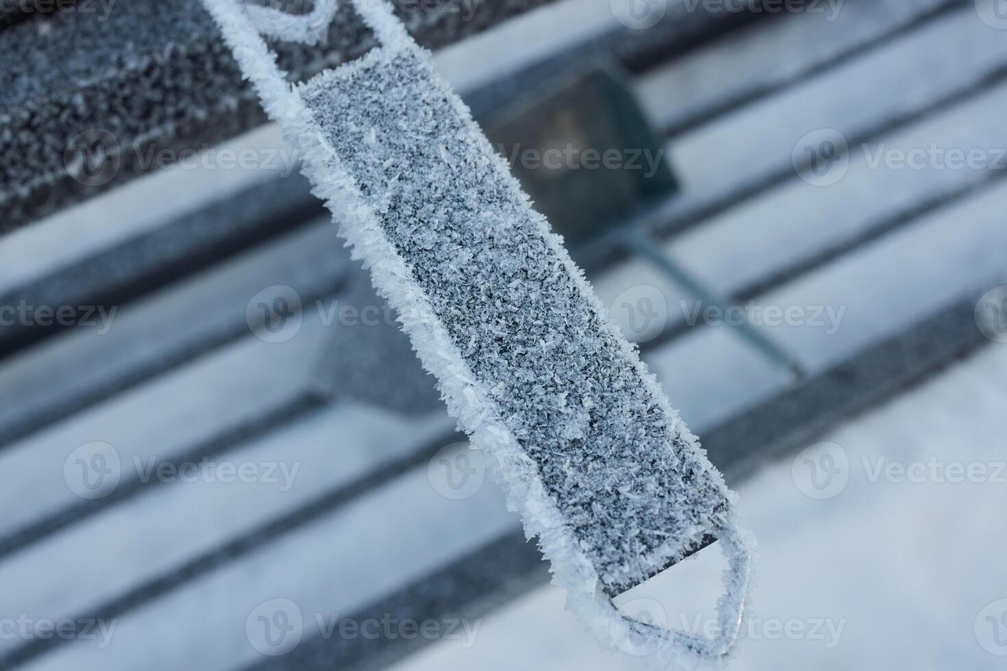 A frosted bench stands out in a winter wonderland, captured in breathtaking artistry photo