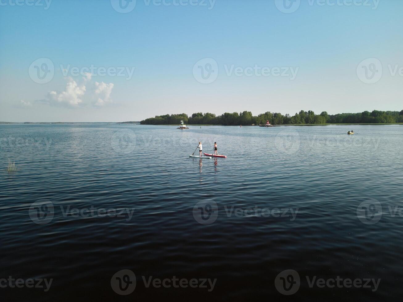 A Serene Lake Scene Featuring Kayakers Enjoying a Beautiful Sunny Day in Natures Embrace photo