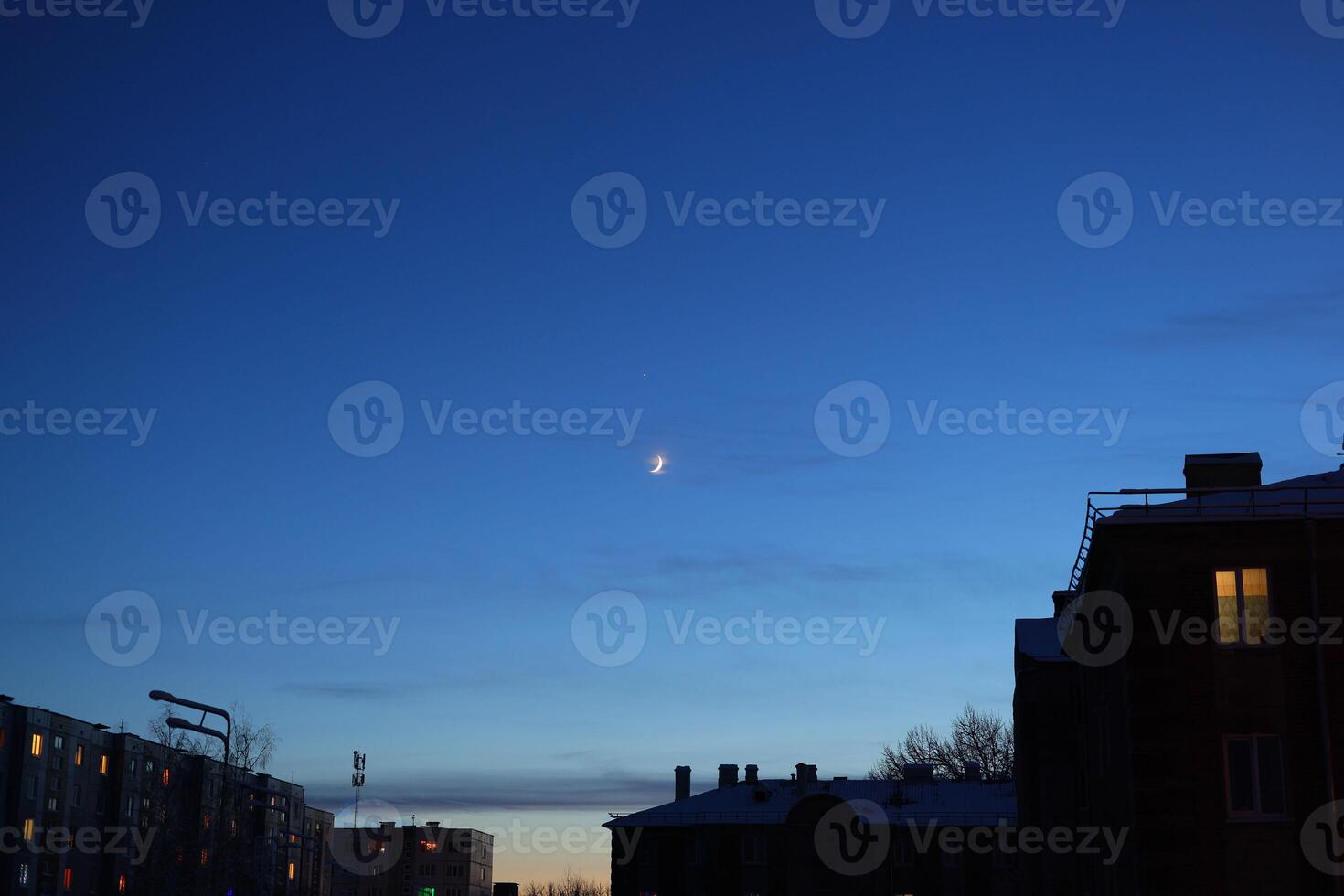 A serene twilight sky with a glowing moon over a stunning urban landscape captivates viewers photo