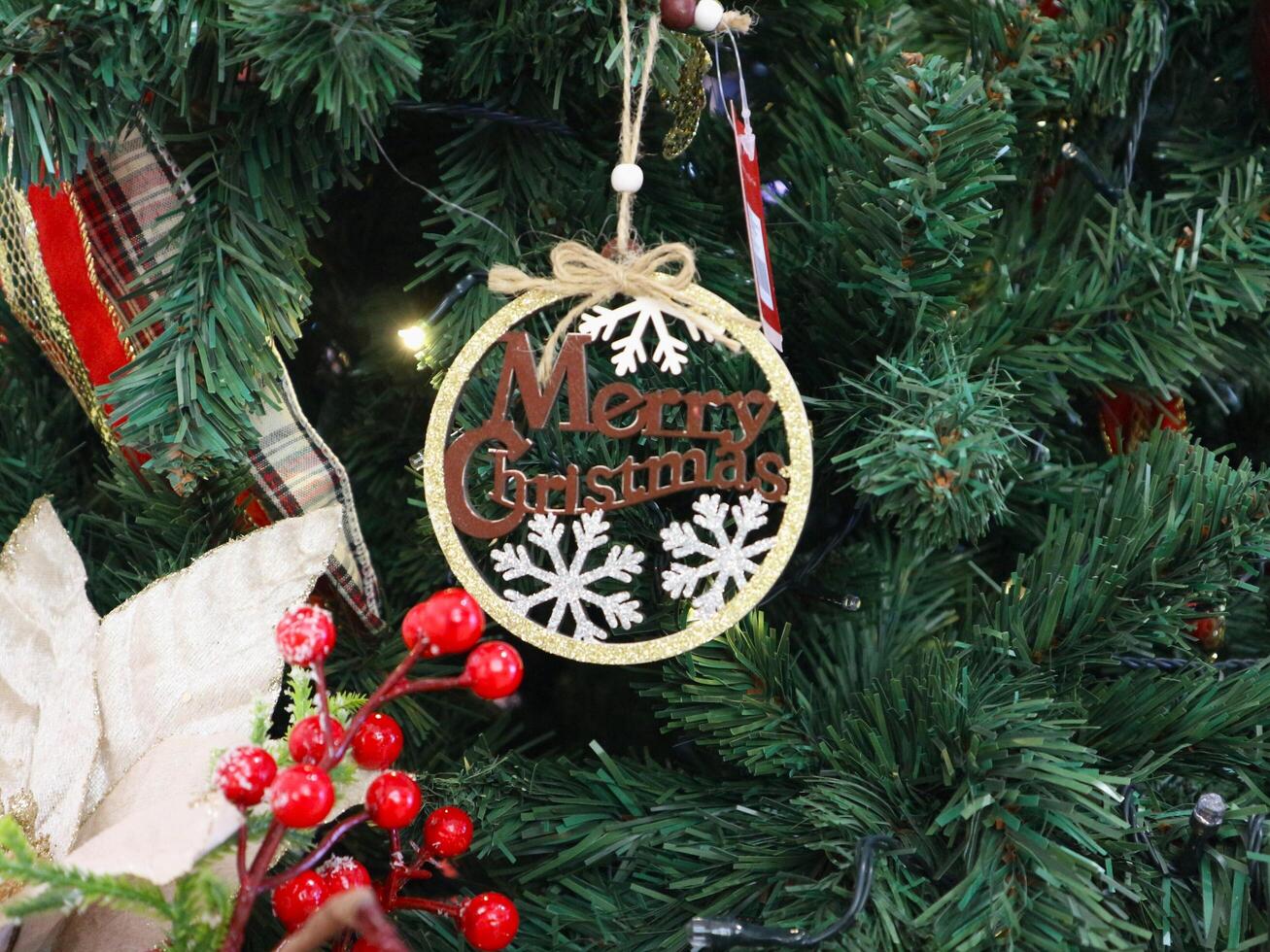 A christmas tree decorated with a merry christmas ornament photo