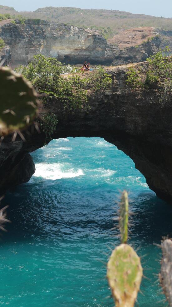 A view of a cliff with a body of water in the background photo