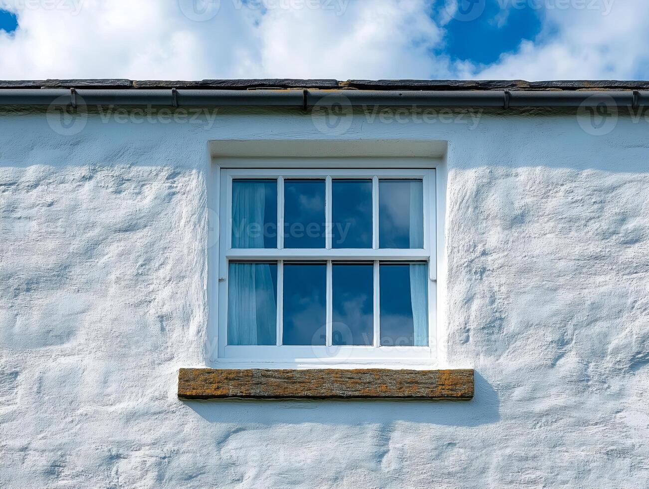 A white house with a window and a brick wall photo