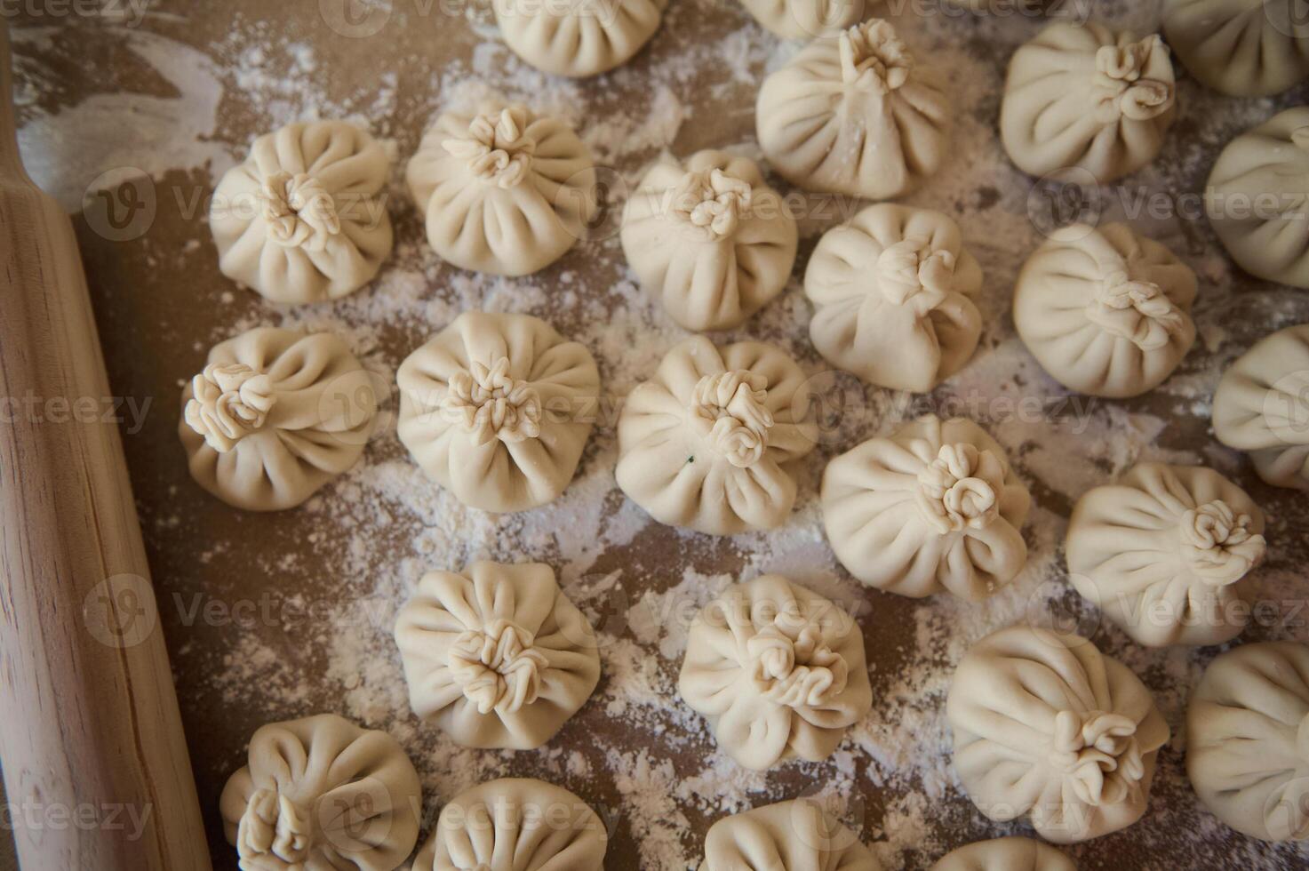 Freshly Prepared Homemade Khinkali Dumplings on a Flour-Dusted Surface photo
