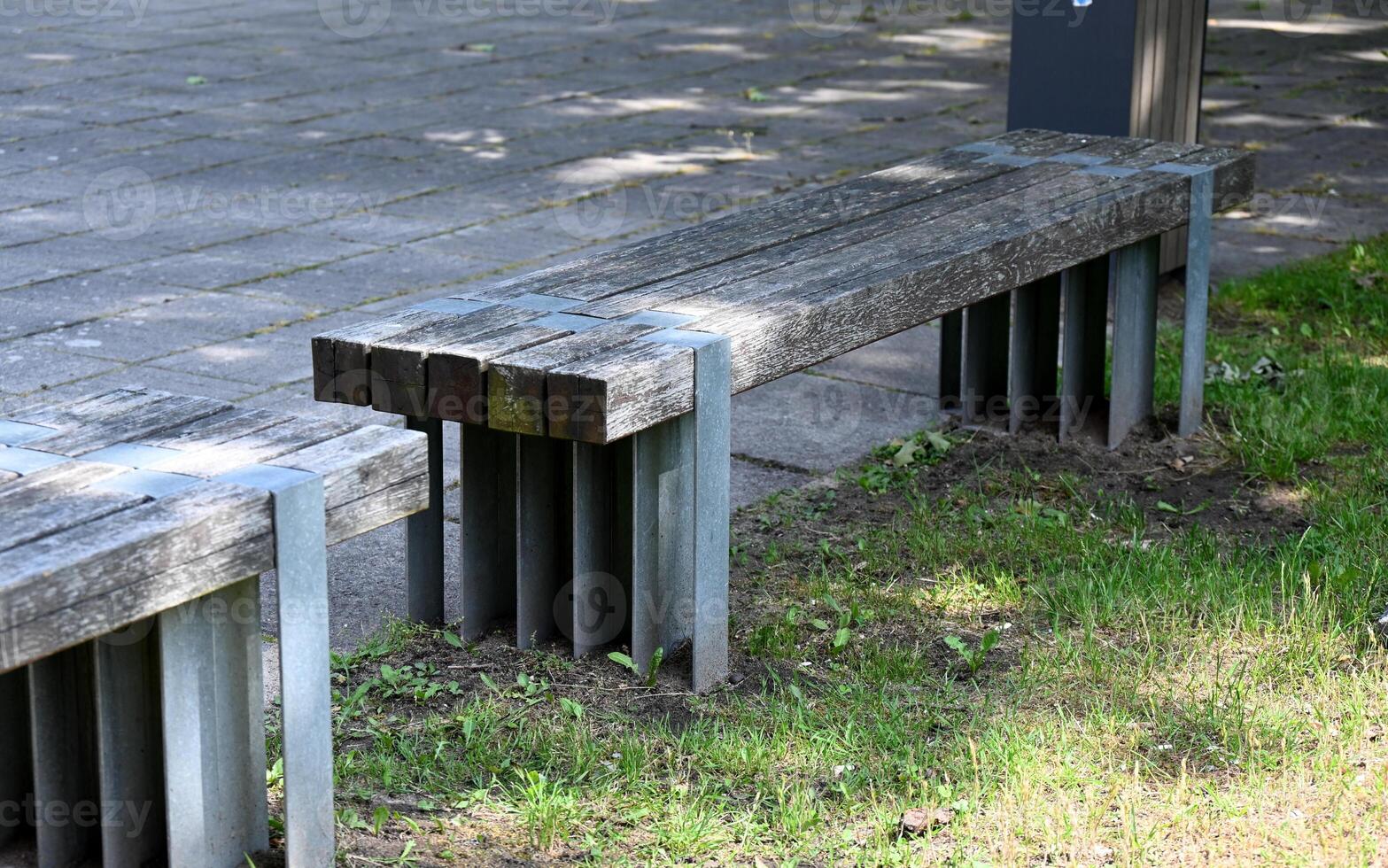 a bench with metal legs sitting on a grassy area photo