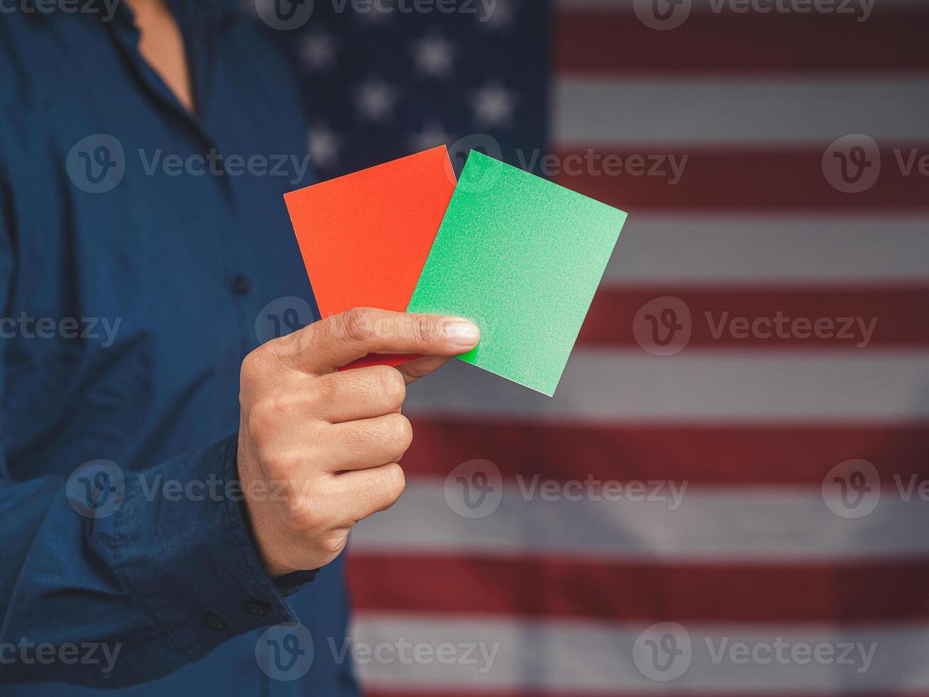 Close-up of hand businessman holding red and green color paper while standing over the American flag background photo