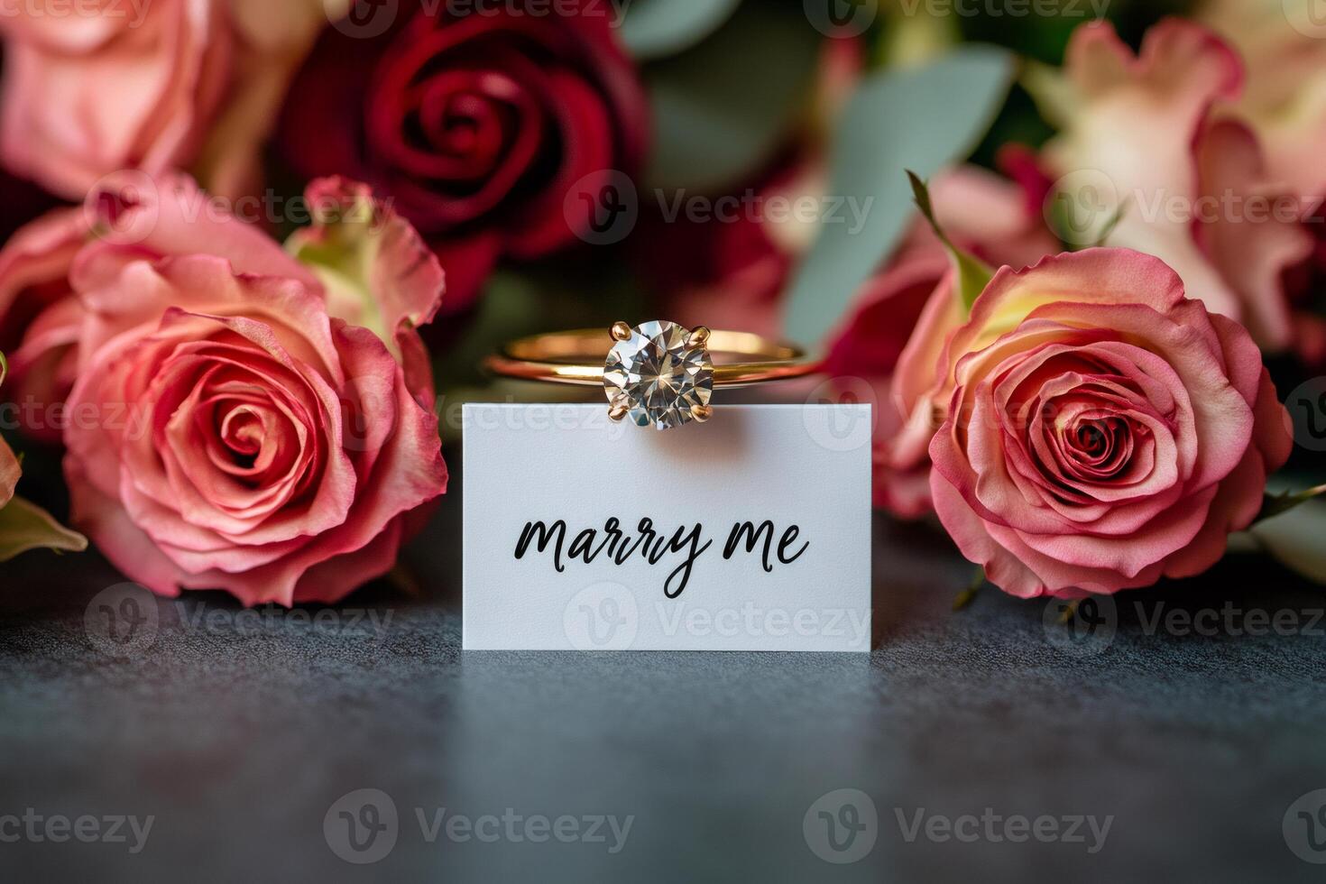 Golden engagement ring placed on marry me card surrounded by roses photo