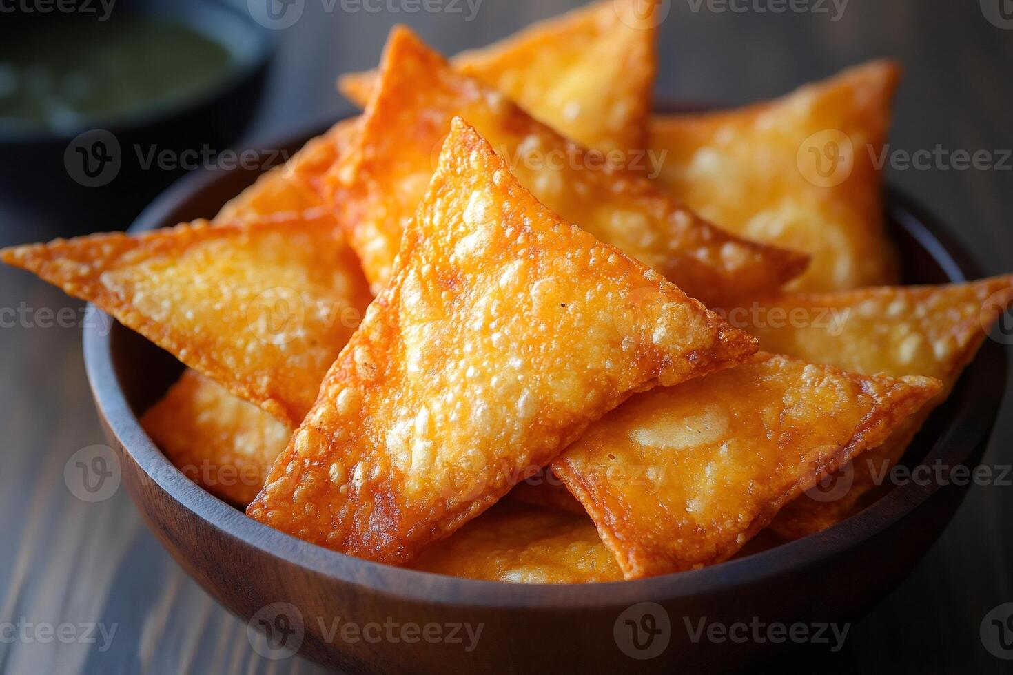 Crispy fried wonton chips with dipping sauce in wooden bowl photo