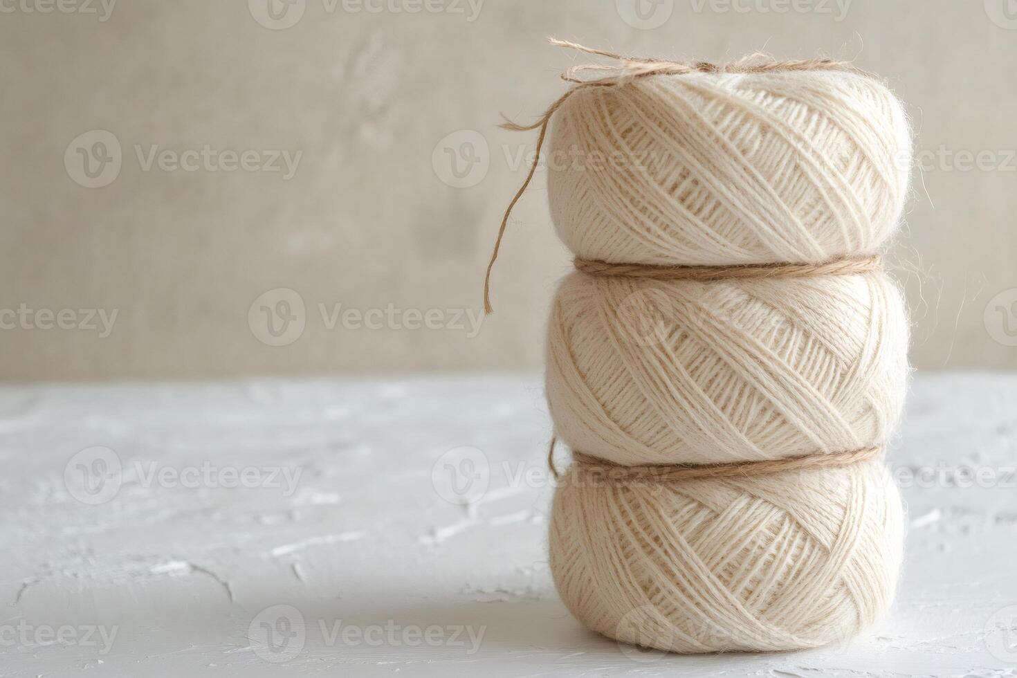 Three skeins of natural wool yarn tied with twine on white surface photo