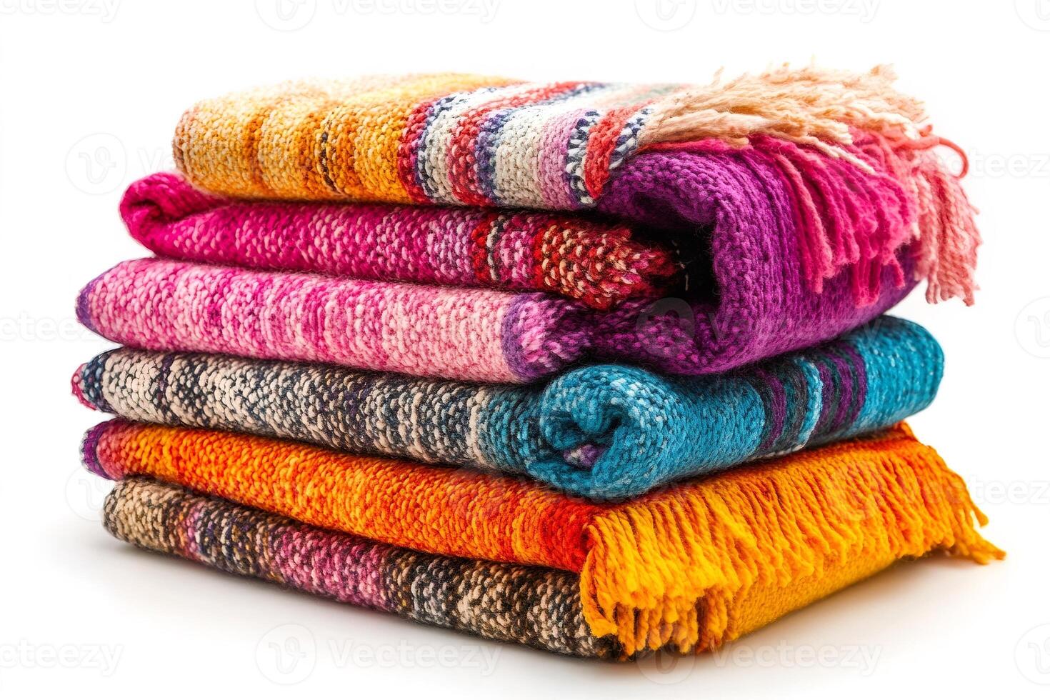 Stack of colorful knitted blankets with tassels on white background photo