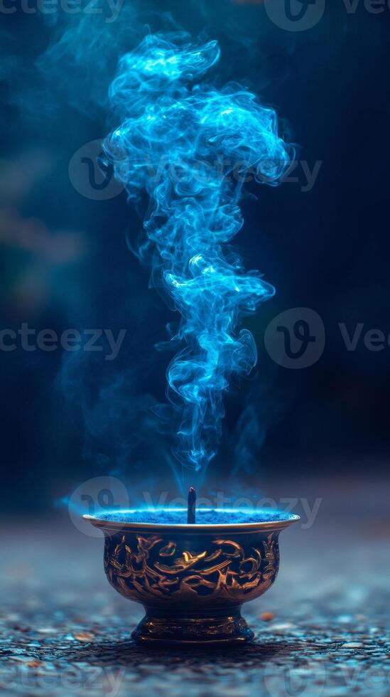 Incense stick burning with blue smoke creating mystical atmosphere photo