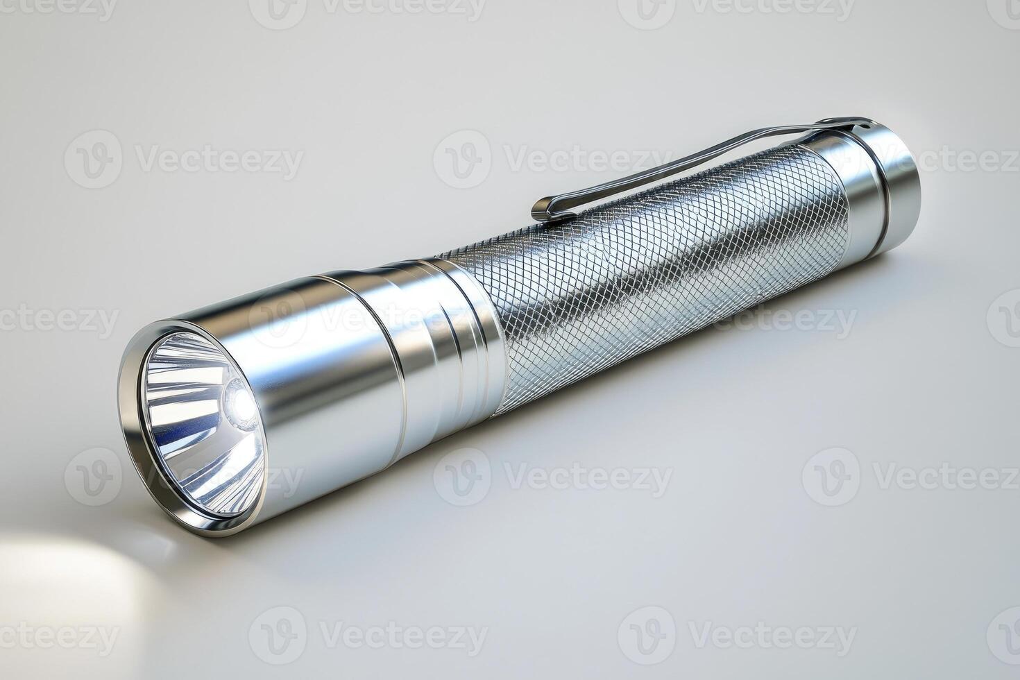 Chrome metal flashlight resting on white background photo
