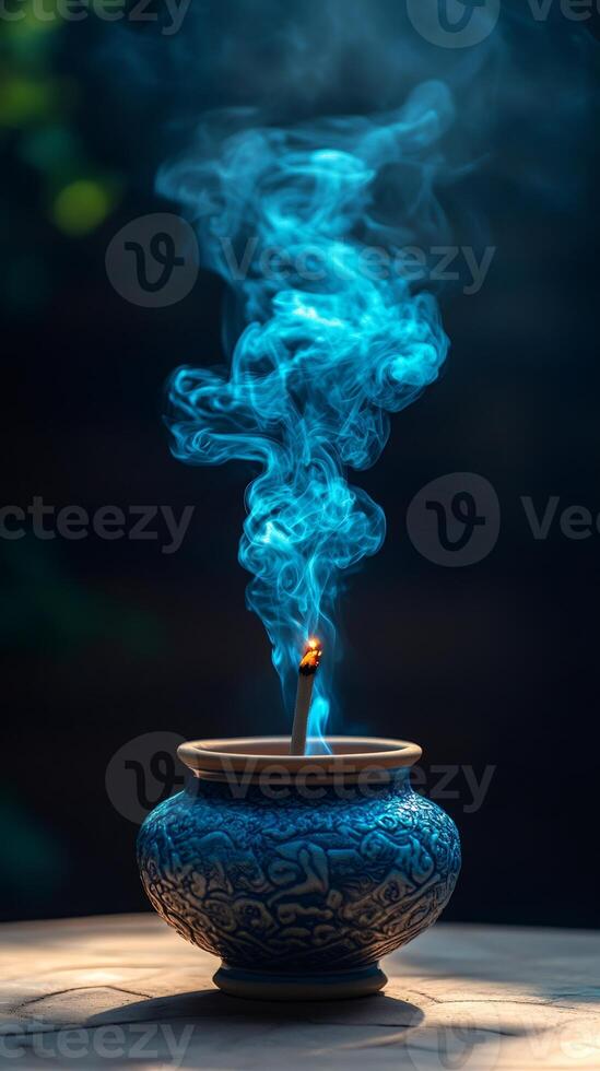 Incense stick burning with blue smoke creating mystic atmosphere photo