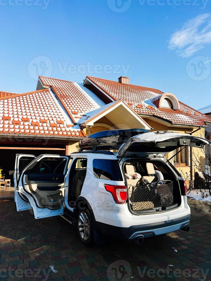 SUV Packed for a Family Trip Outside a Cozy Suburban Home photo