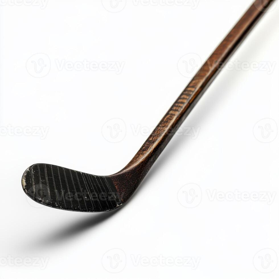 Classic wooden hockey stick resting on a white surface showcasing its curved blade and worn handle photo