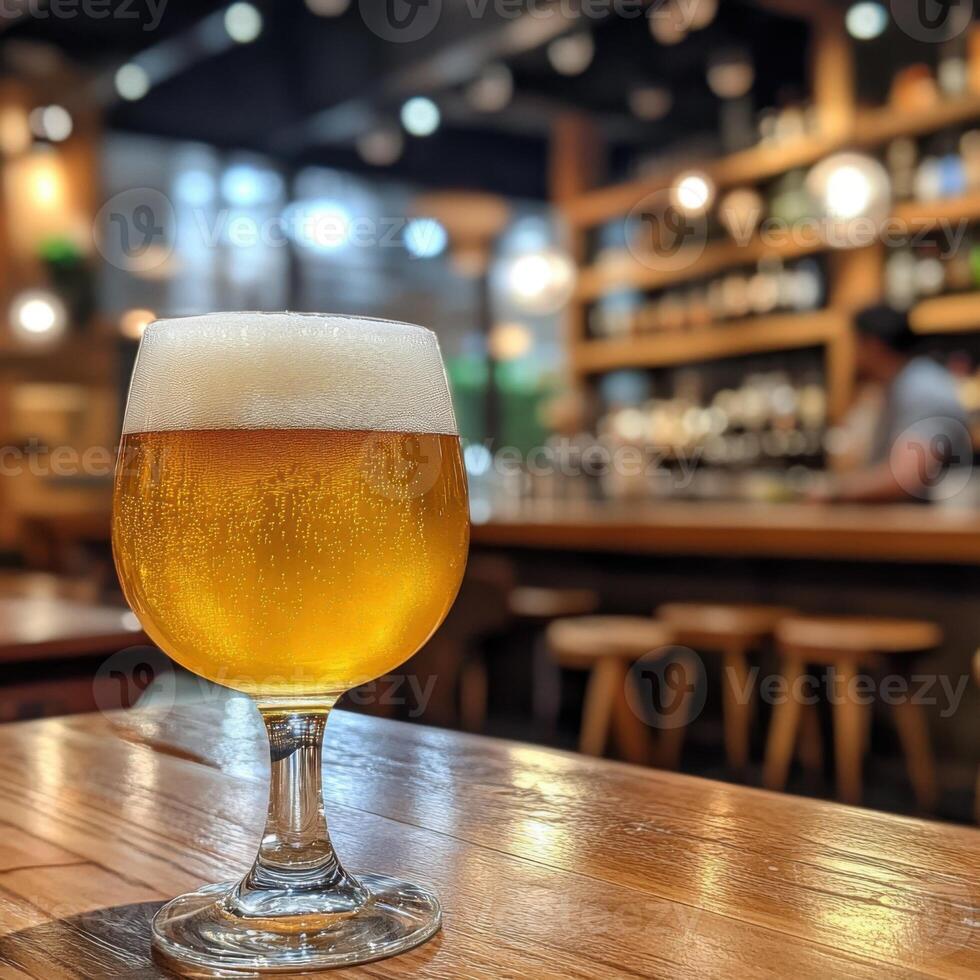 Golden craft beer served in a glass on a wooden table in a cozy bar during evening hours photo