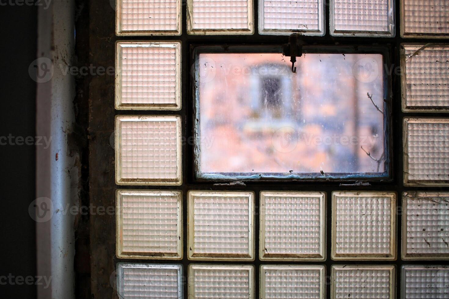 Close-up of a desolate and dirty factory window made of glass bricks photo