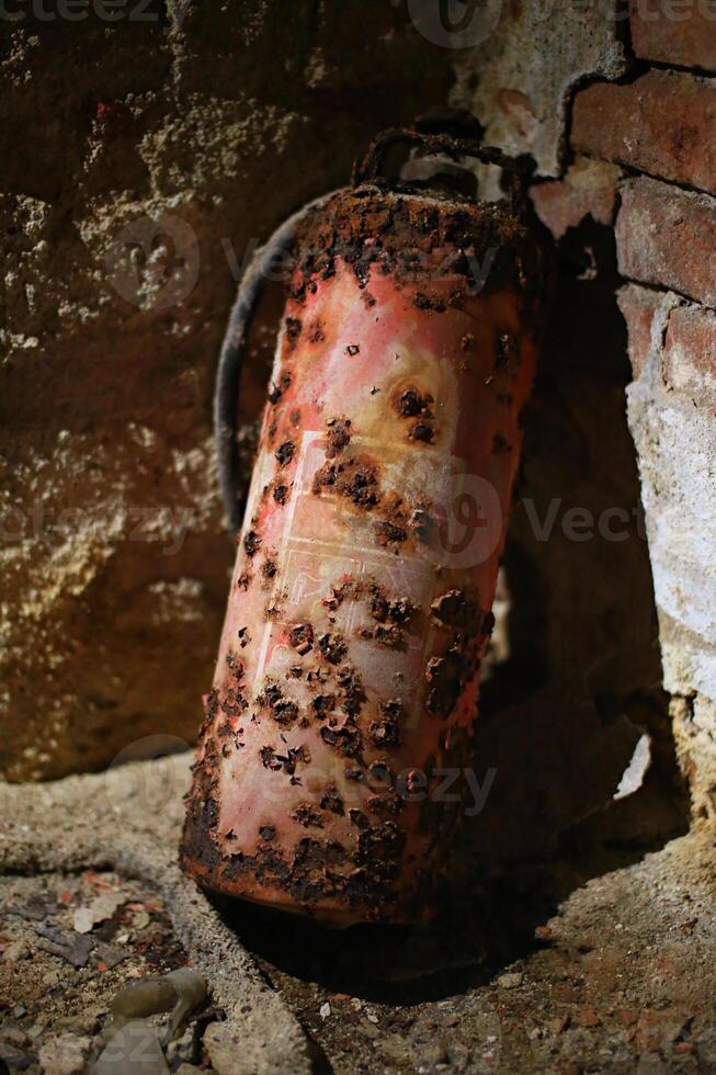 Severely rusted fire extinguisher in moist basement photo