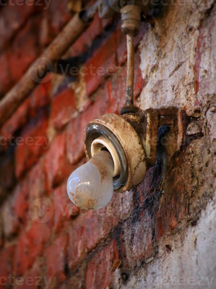 Old grungy lightbulb with broken fitting, making it look sad photo