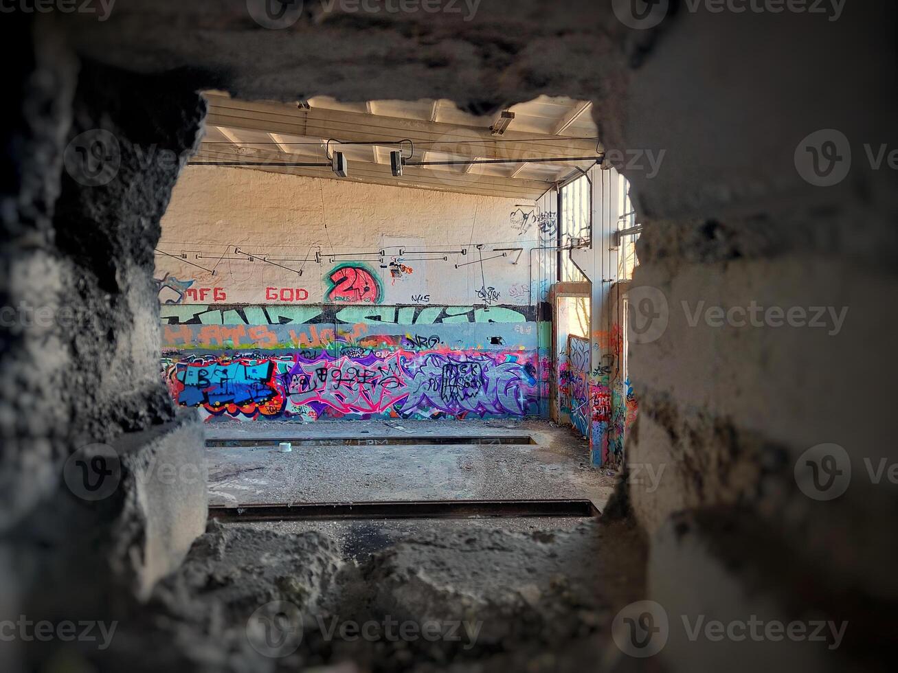 Hole in a brick wall in abandoned factory building photo
