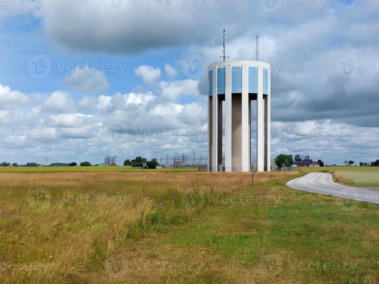 Modern blue and white water tower in agricultural landscape in Trelleborg, Sweden photo