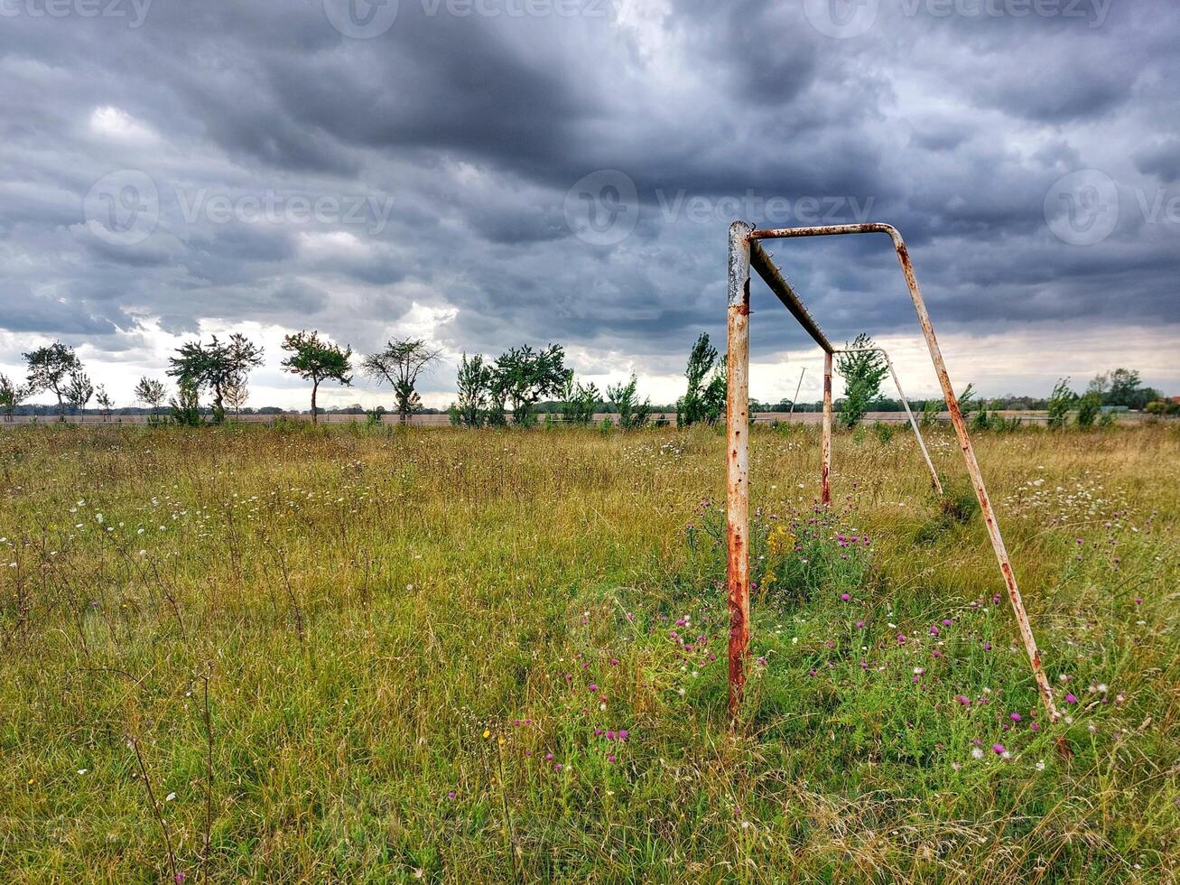 Abandoned soccer field under sky with stormclouds in Germany photo