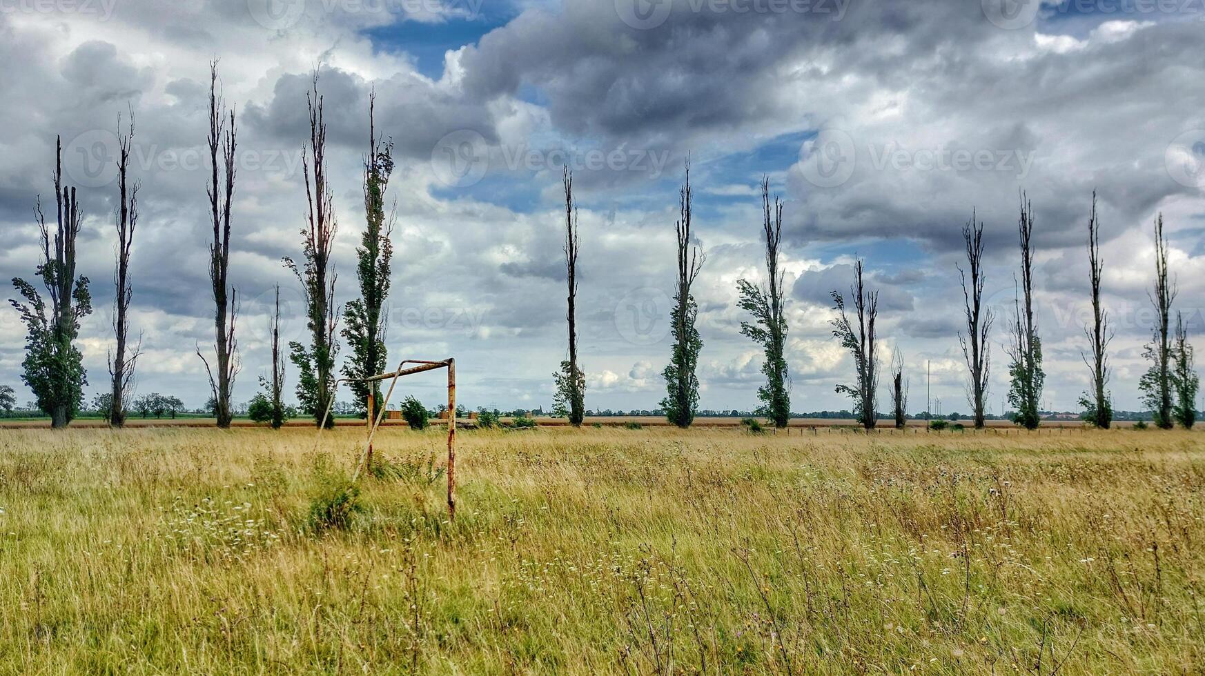 Abandoned soccer field under sky with stormclouds in Germany photo