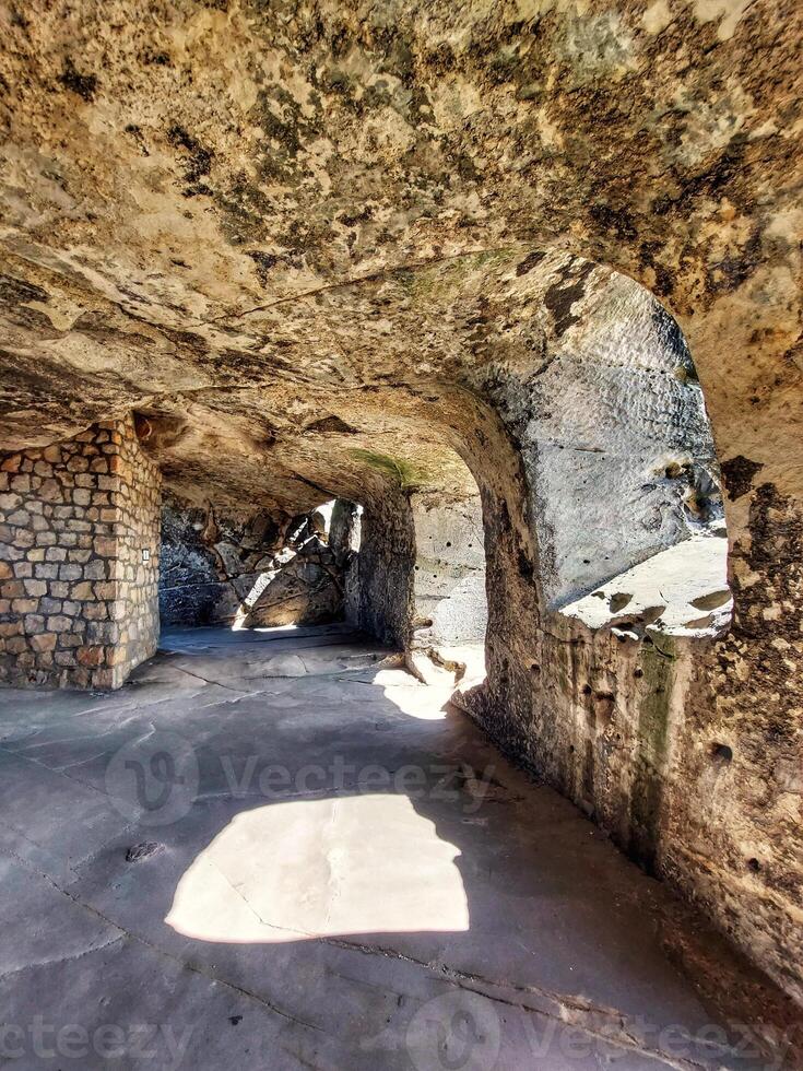 Sunlight falling into underground vault made of rocks photo