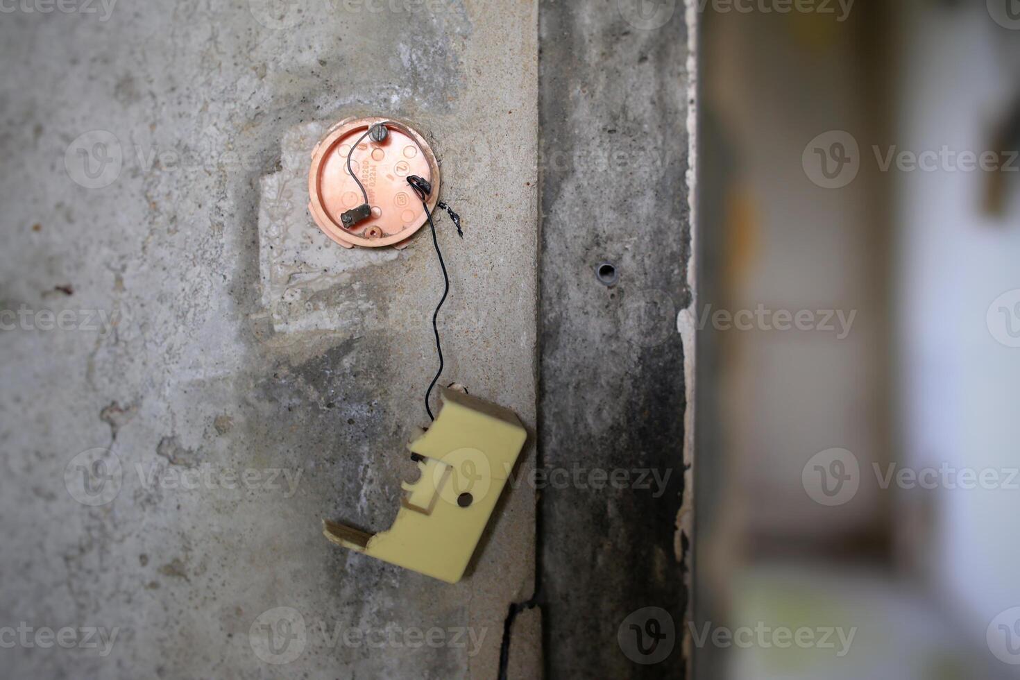 Broken light switch on a concrete wall photo