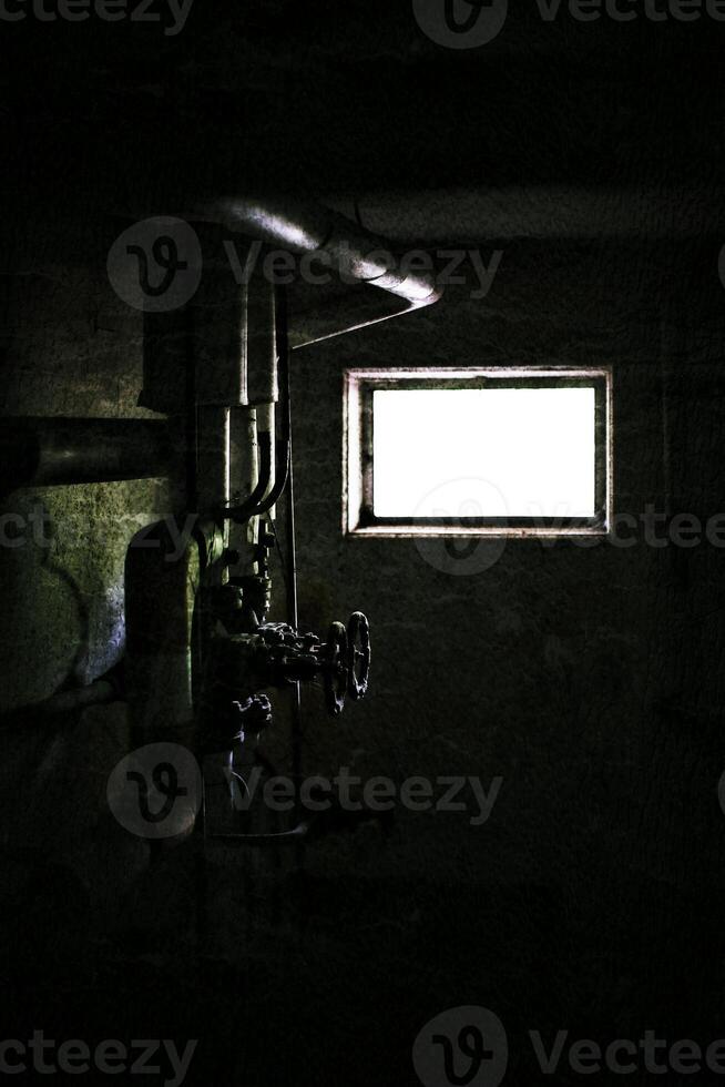 Grungy image of pipes and valves in dark basement photo