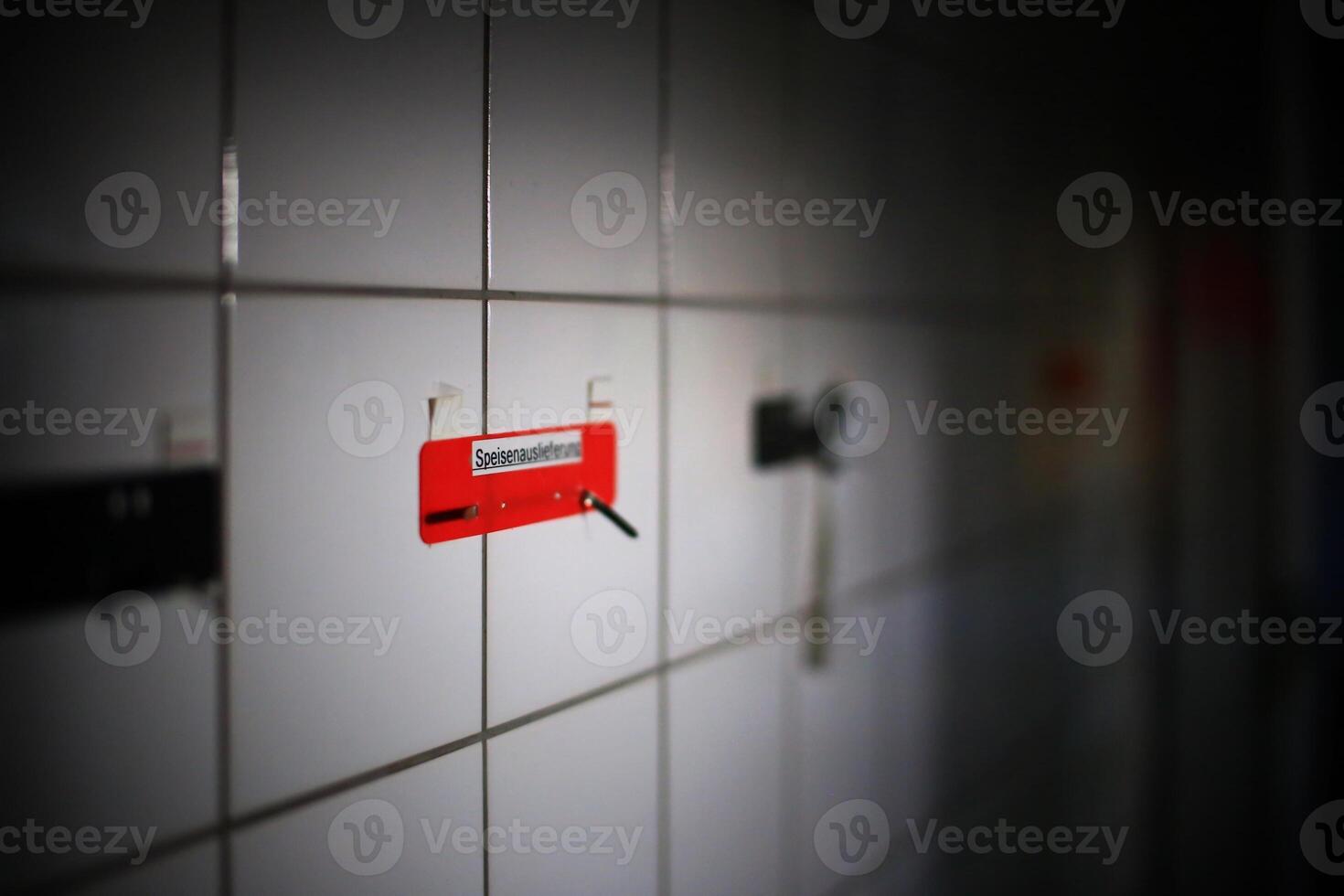 Note on wall in an empty tiled room with the German word Speisenauslieferung - food distribution photo