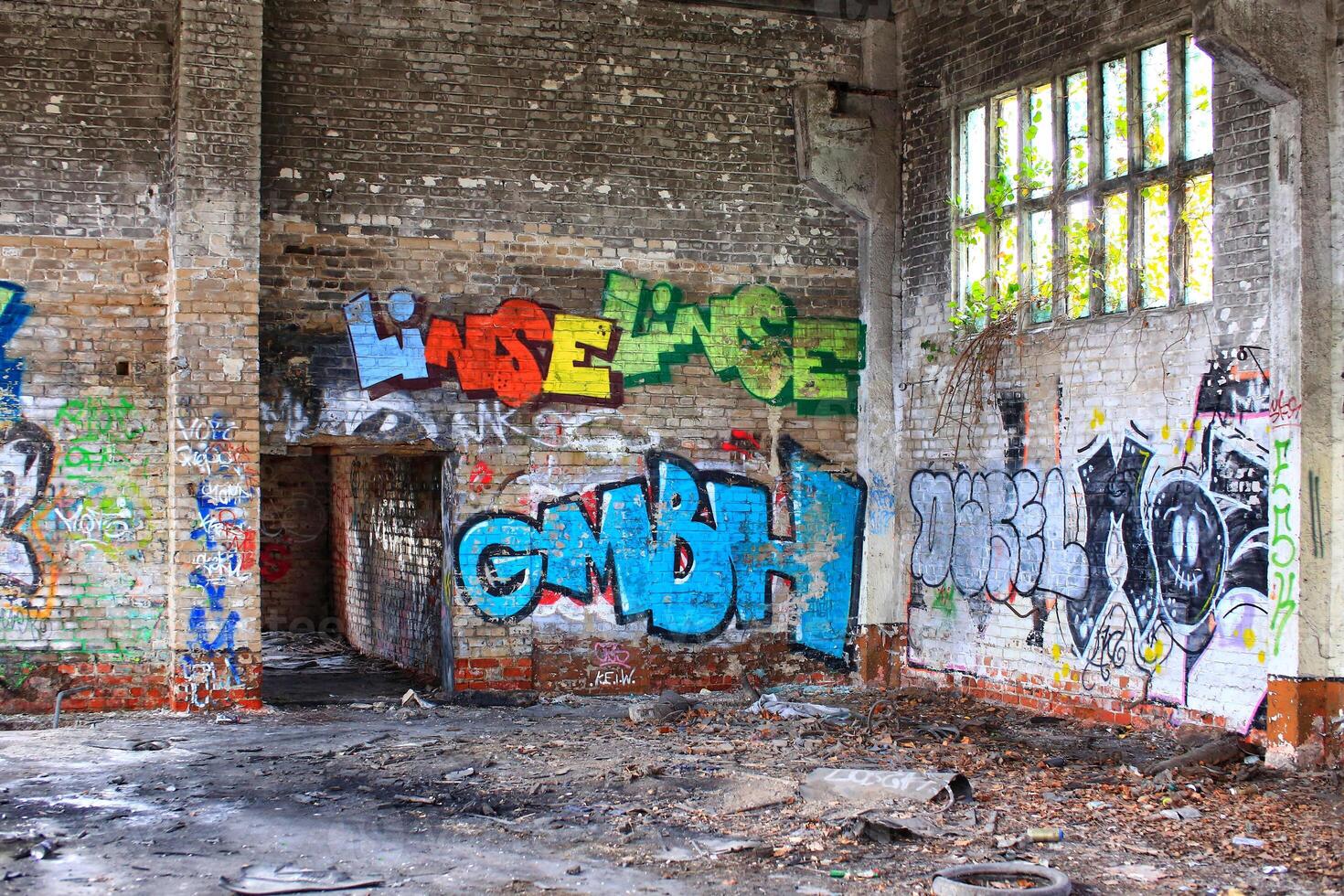 Corner of an abandoned factory hall with graffiti and waste photo