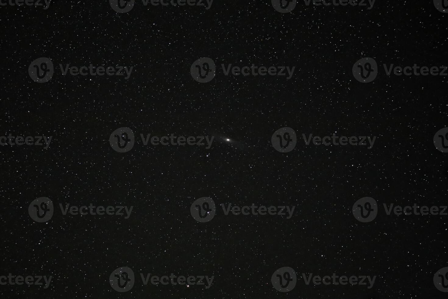 Starry night sky filled with countless visible stars and Andromeda galaxy in the center against a vast dark backdrop photo