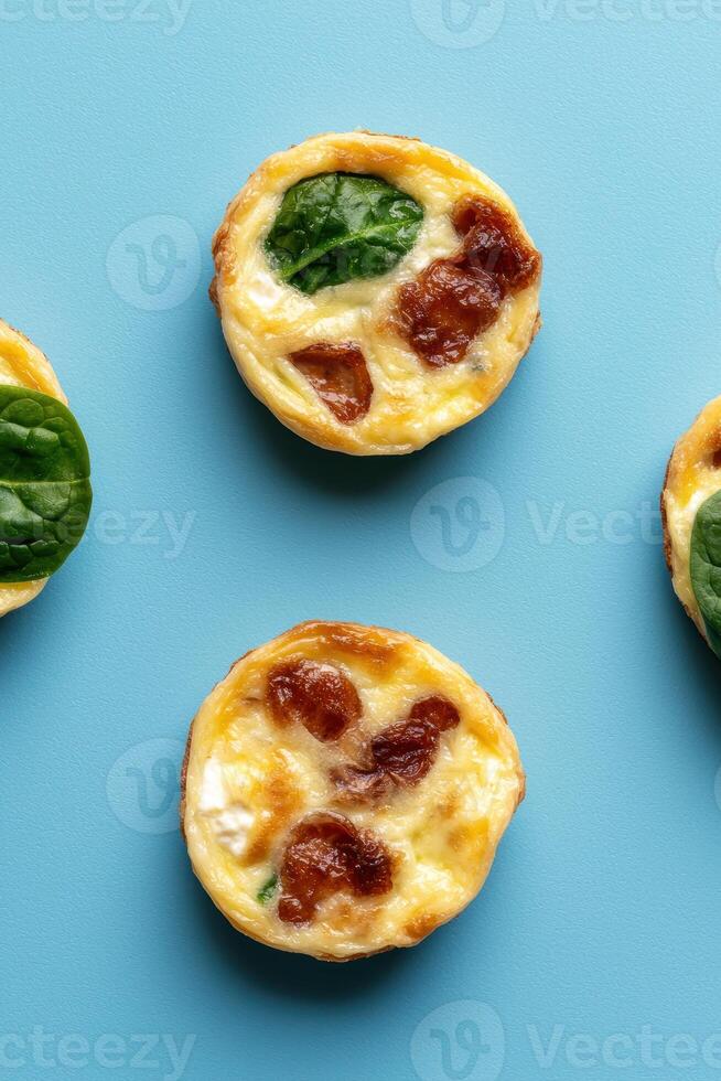 Mini quiche with spinach and bacon on blue background photo