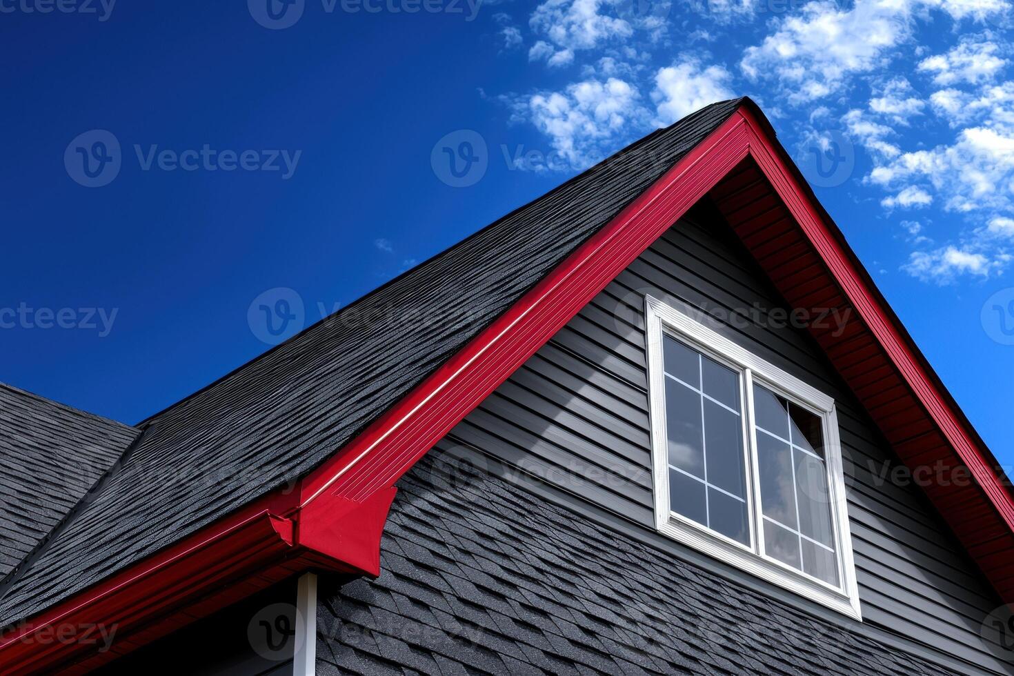 Modern house roof with red trim and gray siding photo