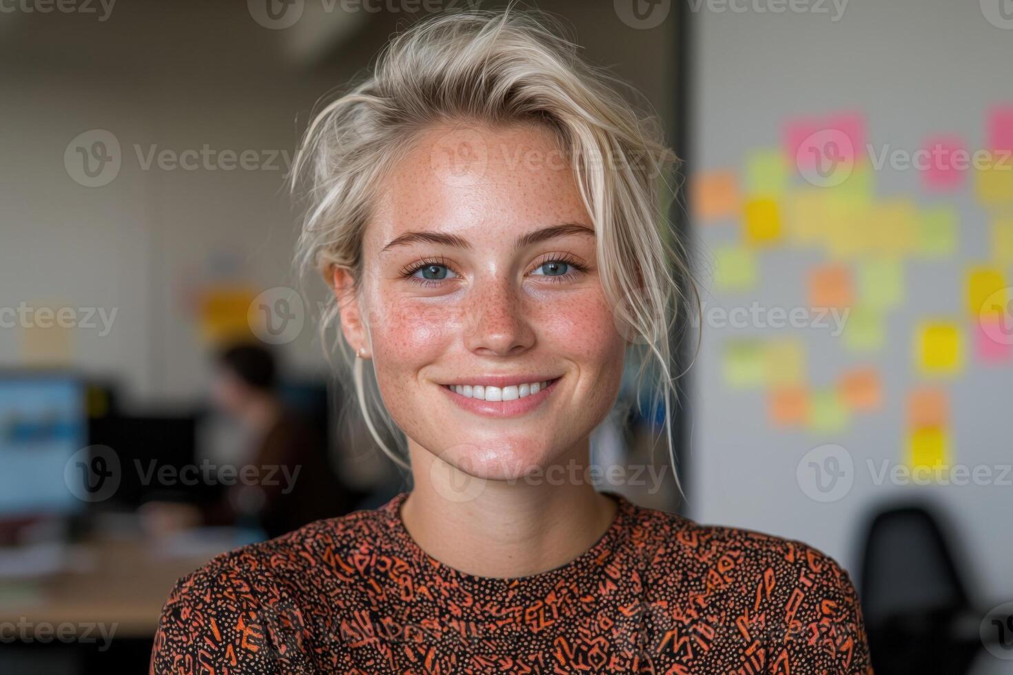 Portrait of a smiling young woman with freckles in an office setting photo