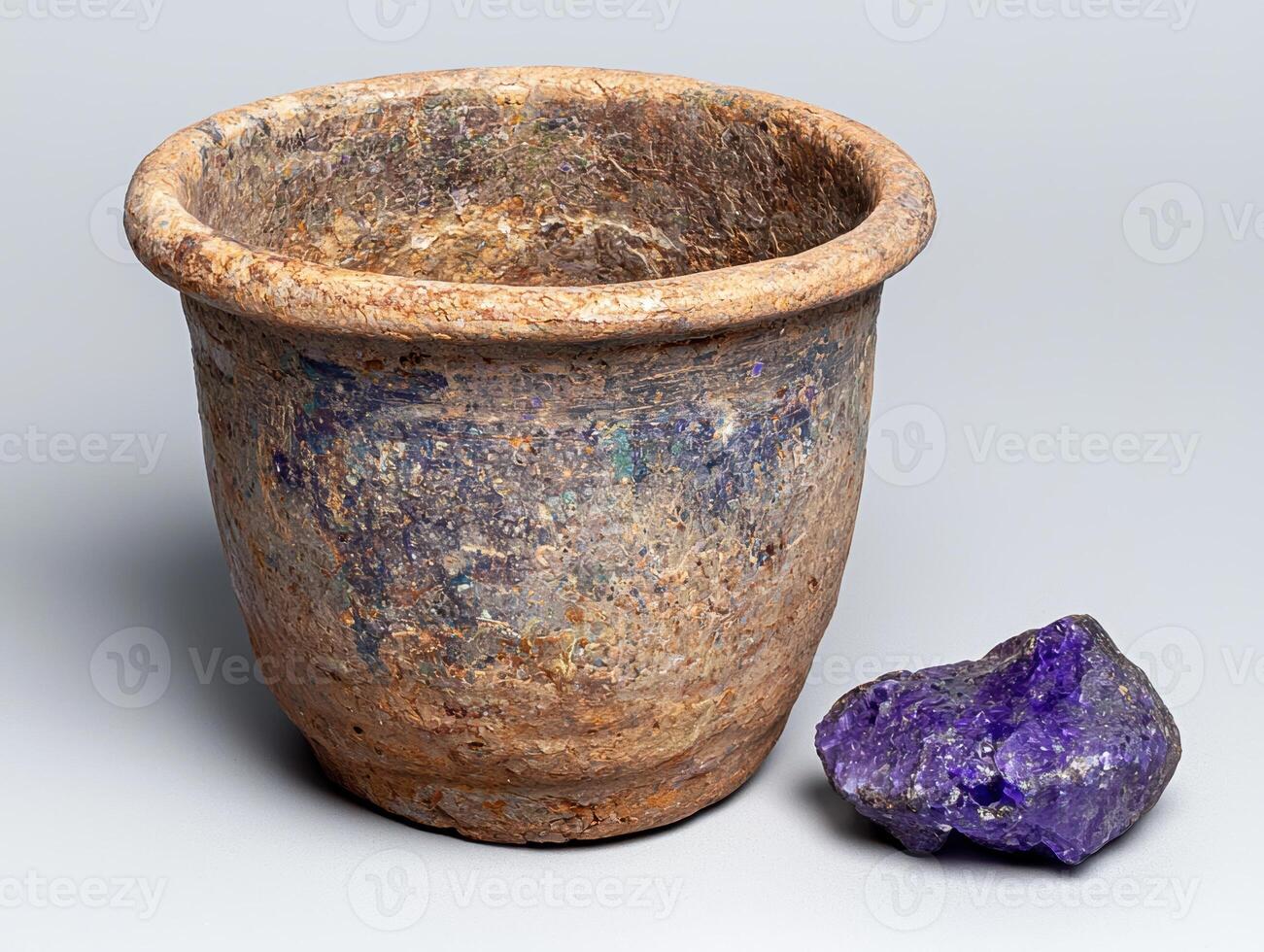 Ancient pot and amethyst geode on neutral background photo