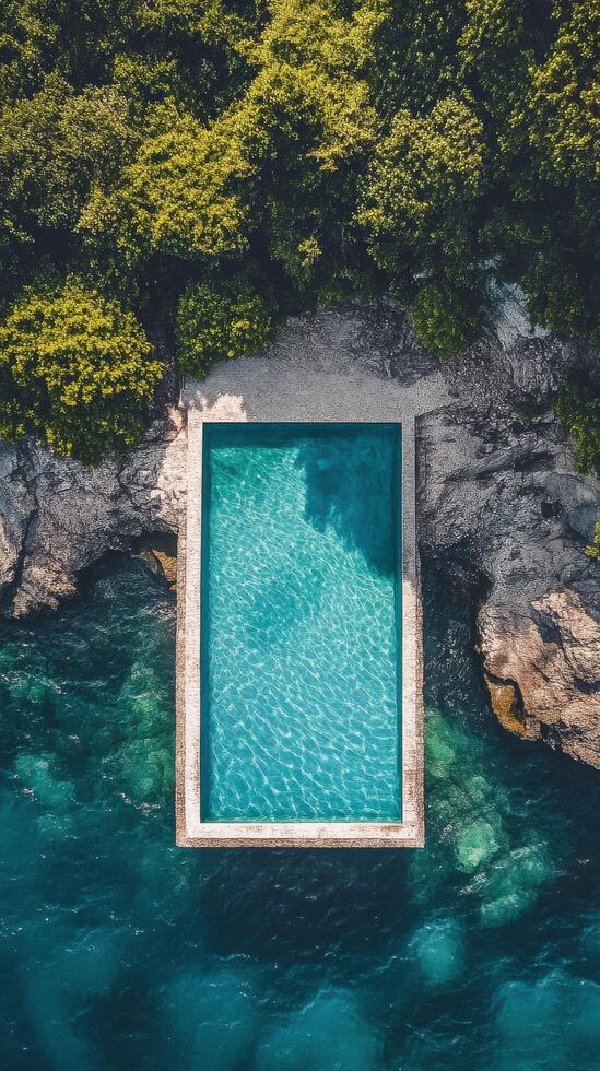 Beautiful cliffside swimming pool overlooking the ocean with clear blue water in a serene location photo