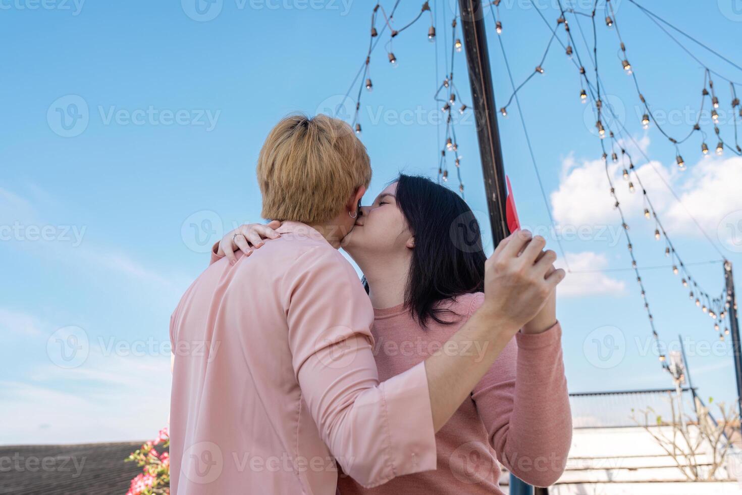 Valentine couple embracing under twinkling lights rooftop romantic moment clear sky intimate viewpoint photo
