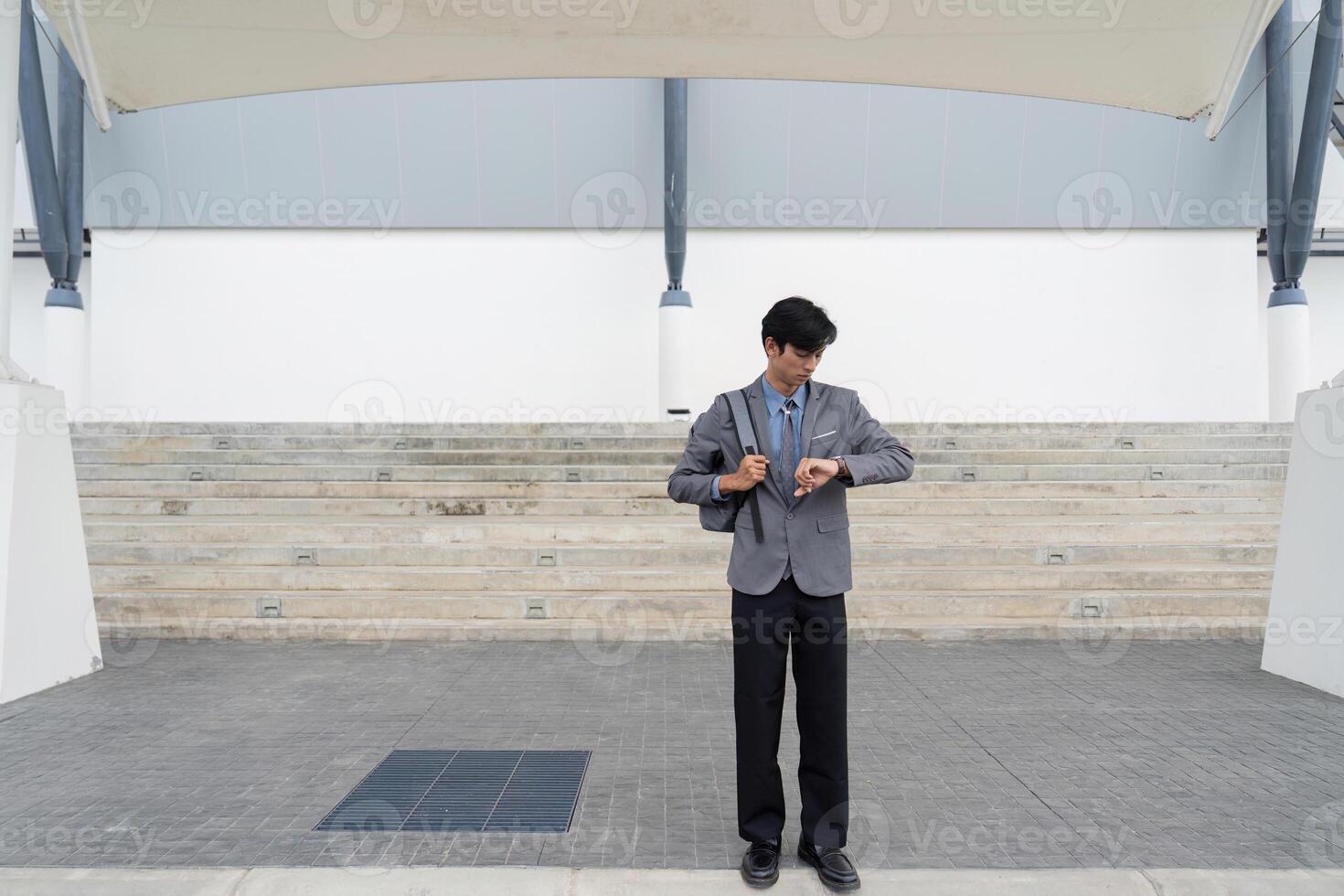 Business professional checking time modern urban setting lifestyle image business environment frontal view time management concept photo
