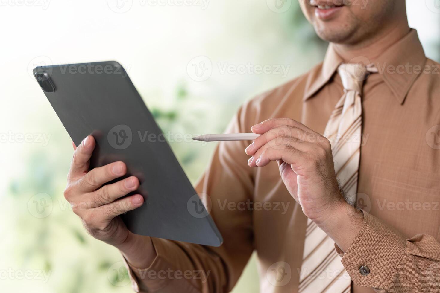 Business professional using tablet with stylus in modern office environment engaging in digital collaboration photo