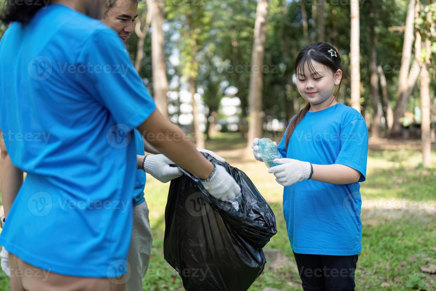 Family volunteer garbage collection event in nature park engaging community for a cleaner environment photo