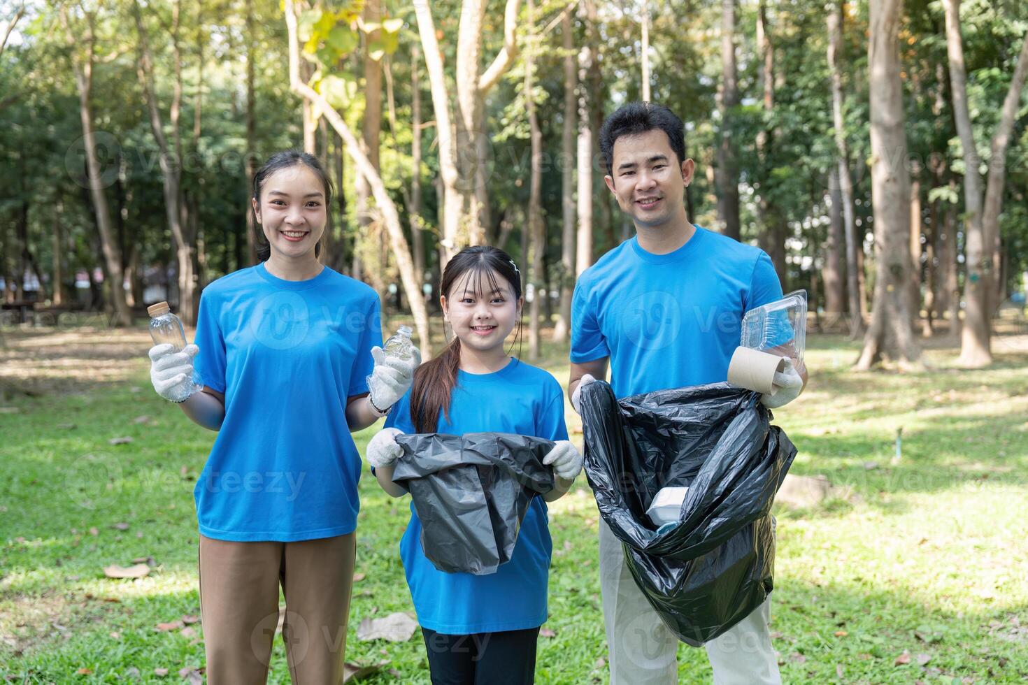 Volunteer family collects garbage in nature park community effort green environment inspiring action photo