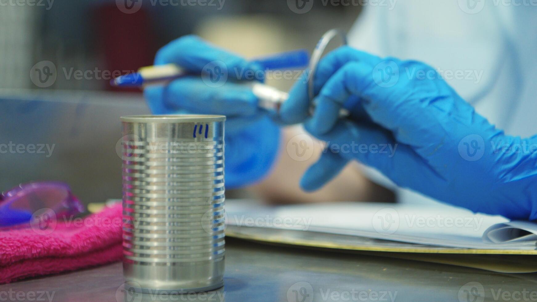Production control supervisor inspects the can in the production line of a canned fish factory photo