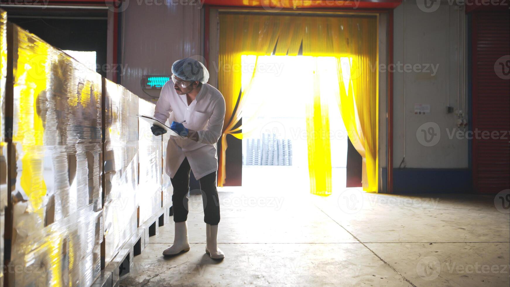 The production supervisor inspects the canned fish boxes that have gone through the packaging process photo