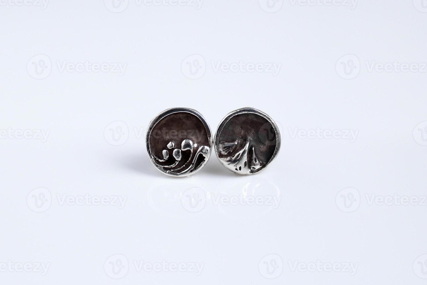 Round silver earrings with a mountain and sea design on a white background. Handmade jewelry. photo