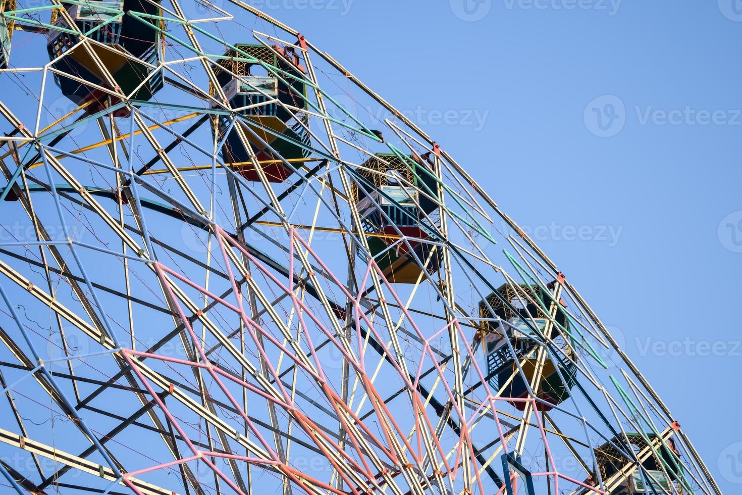 Closeup of multi-coloured Giant Wheel during Dussehra Mela in Delhi, India. Bottom view of Giant Wheel swing. Ferris wheel with colourful cabins during evening time. photo