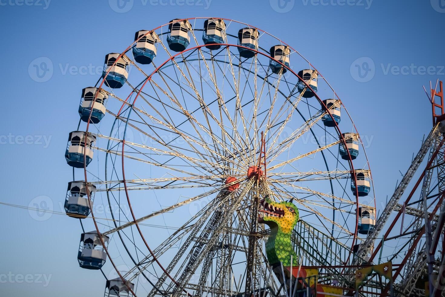 Closeup of multi-coloured Giant Wheel during Dussehra Mela in Delhi, India. Bottom view of Giant Wheel swing. Ferris wheel with colourful cabins during evening time. photo