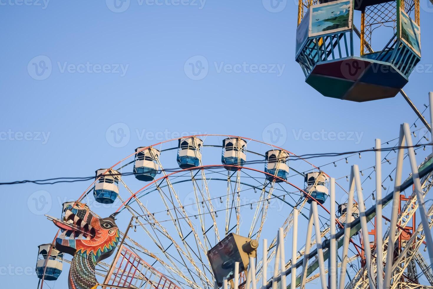 Closeup of multi-coloured Giant Wheel during Dussehra Mela in Delhi, India. Bottom view of Giant Wheel swing. Ferris wheel with colourful cabins during evening time. photo