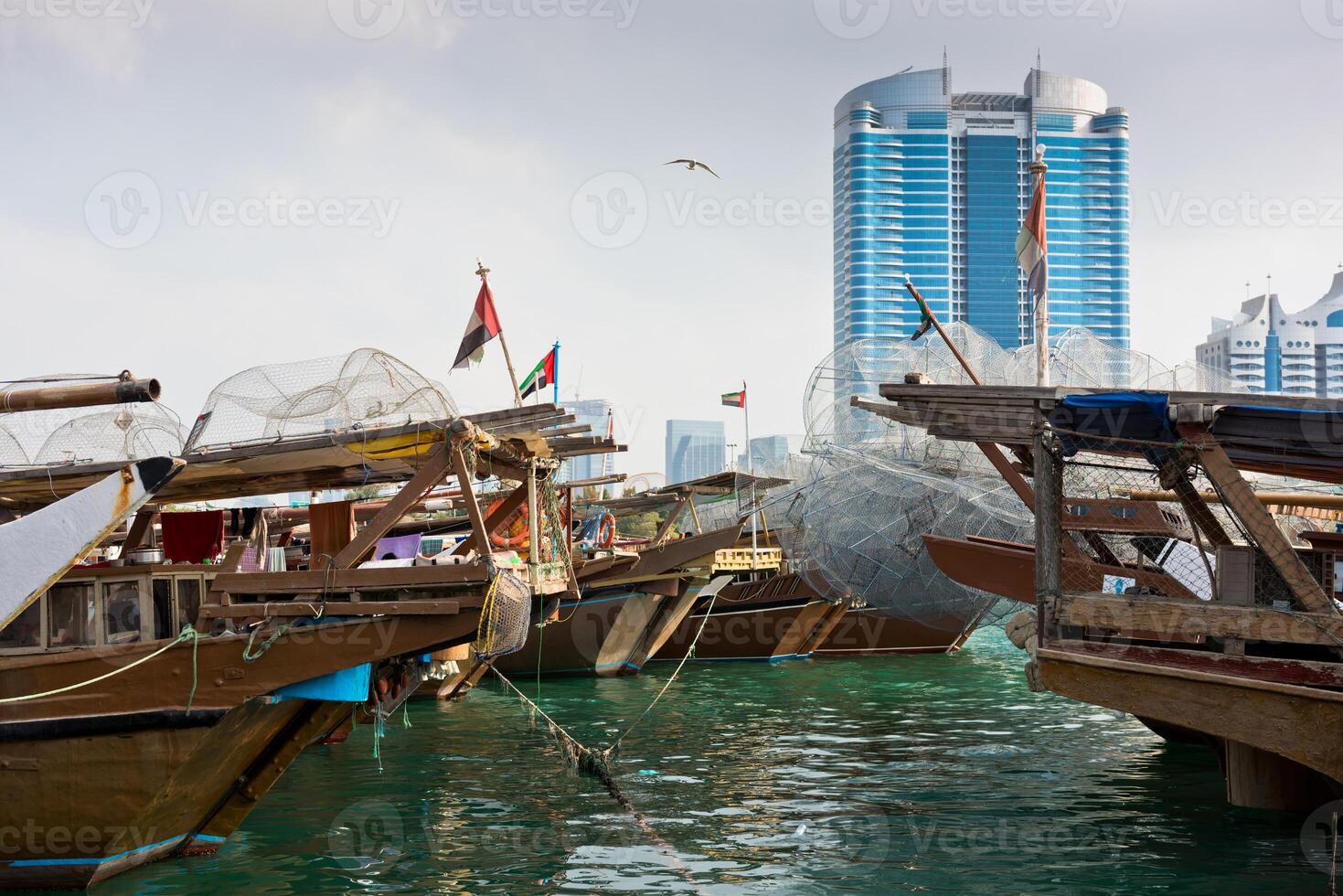 Abu Dhabi buildings skyline with old fishing boats photo