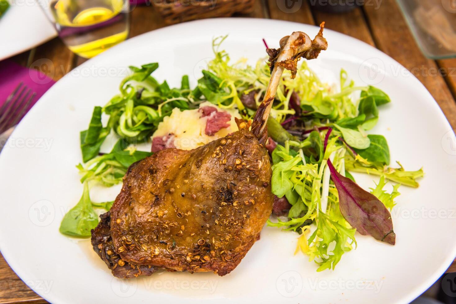 Dish with a roasted duck leg and green salad photo